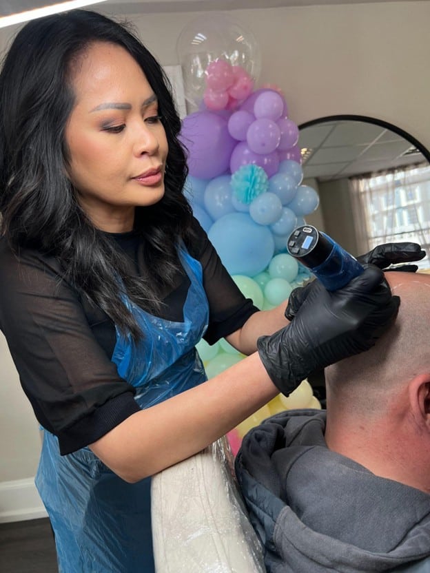SMP student with no prior experience practising scalp micropigmentation on a live model under instructor supervision at best SMP-Clinic Stockport.